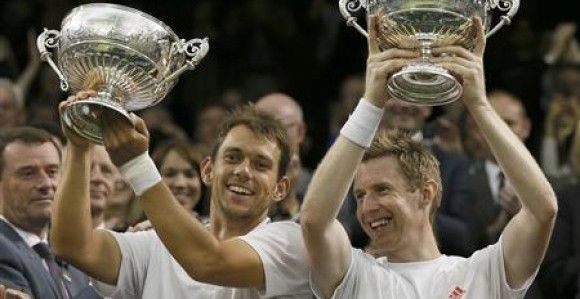 Jonathan Marray of Britain and his partner Frederik Nielsen of Denmark hold their trophies after defeating Robert Lindstedt of Sweden and Horia Tecau of Romania in their men's doubles tennis match at the Wimbledon tennis championships in London